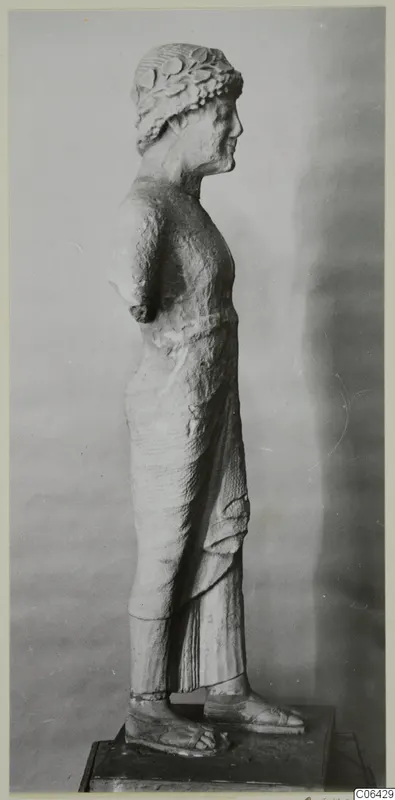 Limestone statue of a standing figure in profile, Kition, wearing a wreath and long draped garment with sandals