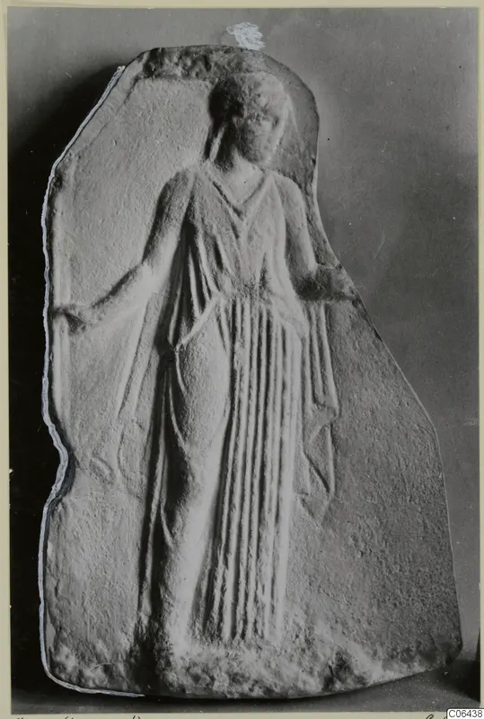 Marble relief plaque of a standing female figure in a long draped garment, with vertical folds