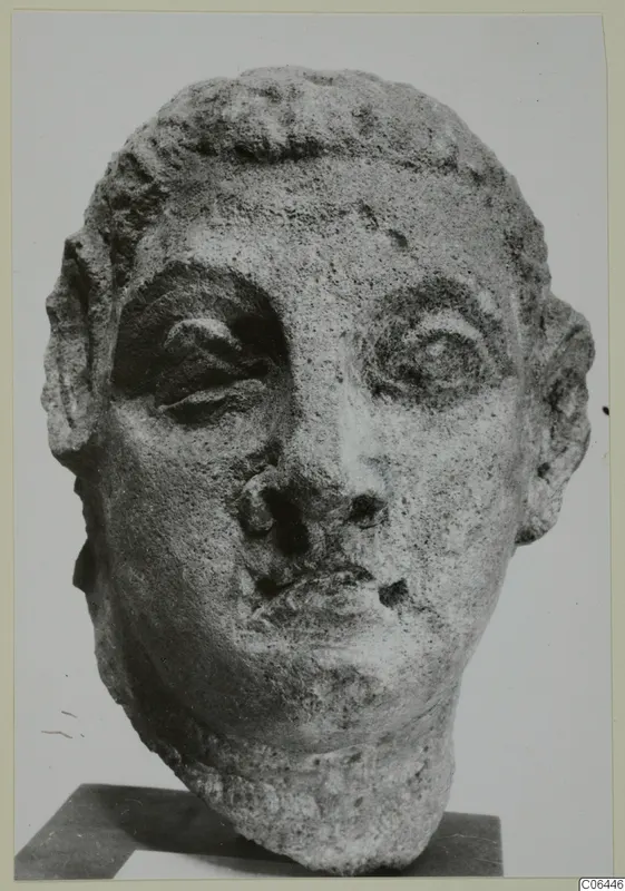 Carved head sculpture from Mersinaki with large eyes, short hair in rows and a chipped nose
