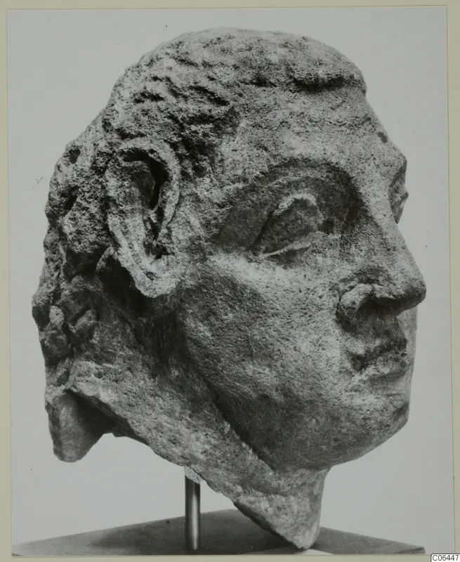 Carved stone head with short curled hair and a visible ear, turned to the right, from Mersinaki