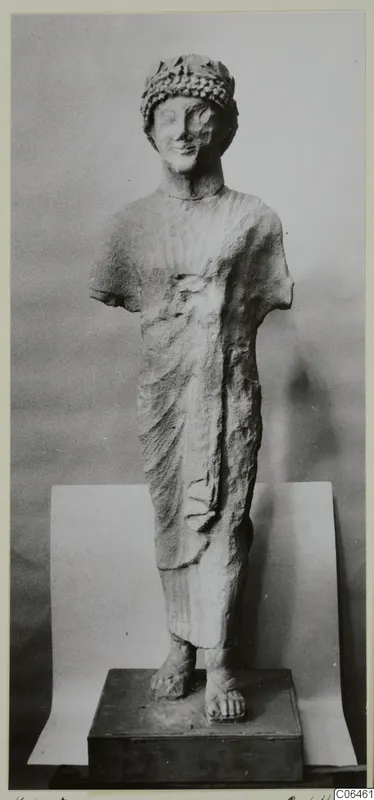 Limestone sculpture of a standing figure with a leafy wreath, arms broken off, on a dark plinth
