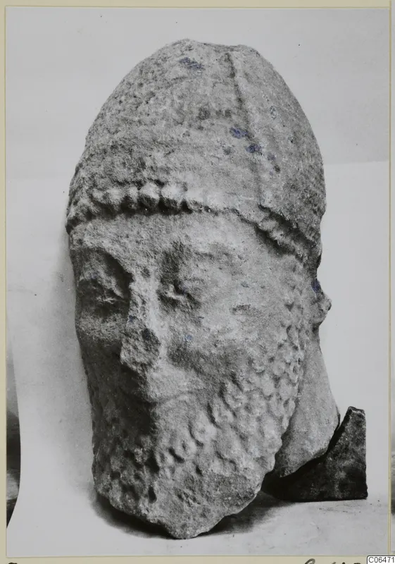 Limestone head from Kition, Oura S, with a tall headdress, a knobbed band across the brow and a worn face