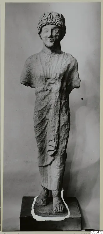 Limestone statue from Kition of a standing figure with a wreath-like headdress; arms broken off