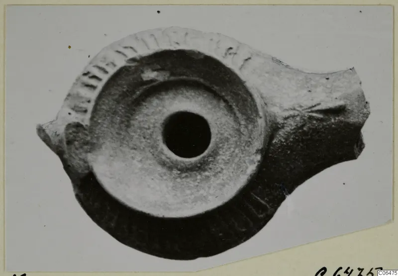 Terracotta oil lamp seen from above, with impressed decoration around the rim