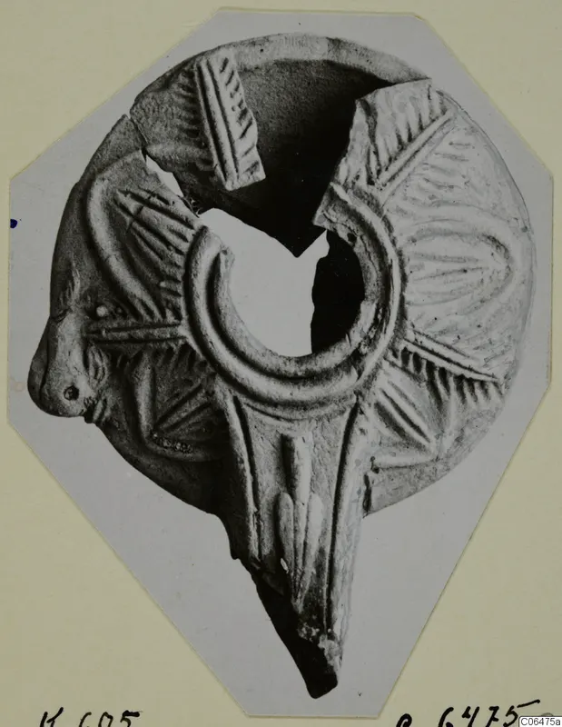 Terracotta lamp with radiating ridged decoration, a small head at the left and a large ring-shaped filling hole at the centre.