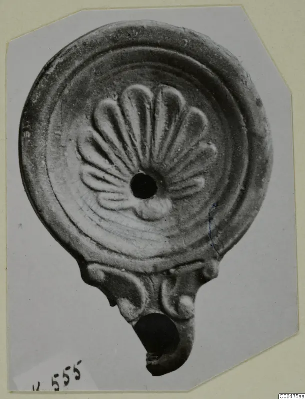 Terracotta oil lamp with a fan of raised petal shapes around its filling hole