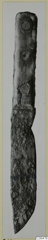 Iron knife with three rivets along its handle, photographed upright against a pale background.