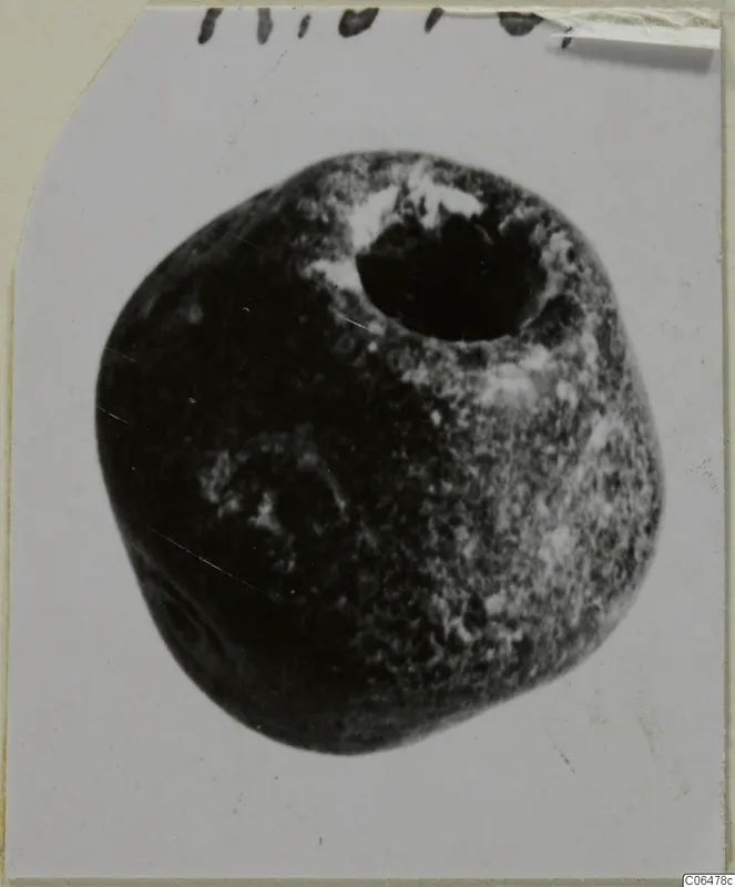Rounded stone object from Kition with a large hole in its top, photographed on a card