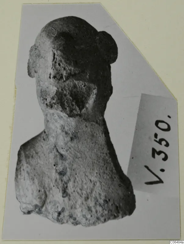 Terracotta figurine of a head and shoulders, with a rounded knot of hair on top of the head