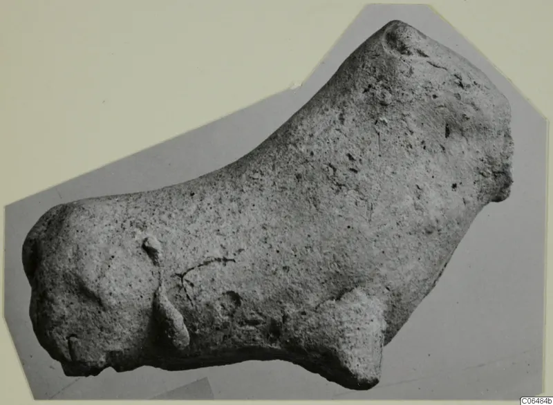 Terracotta figurine of a small animal, shown in side view on a grey mount