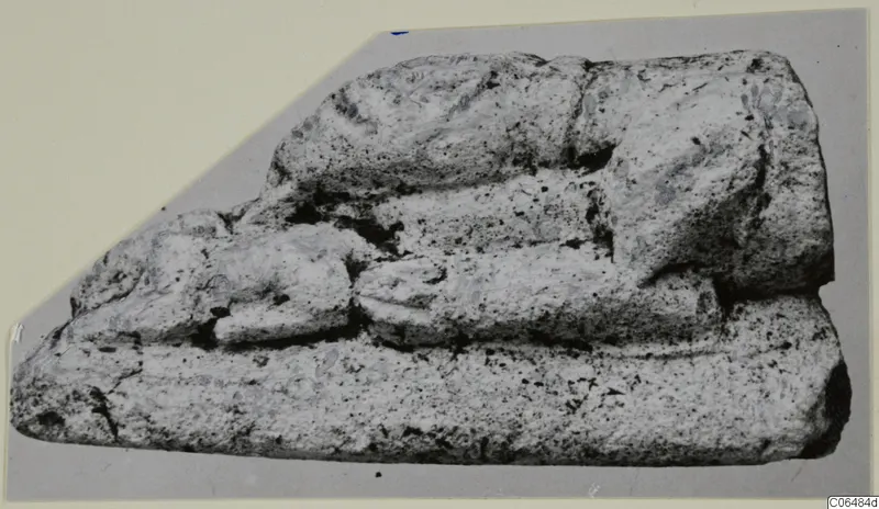Weathered limestone fragment from Vouni with rounded, tiered forms, photographed on grey card