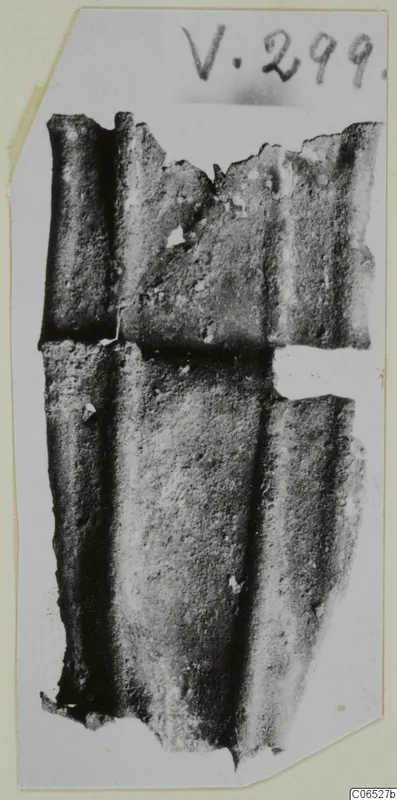 Bronze sheet fragments with parallel raised ribs, photographed against a pale card background
