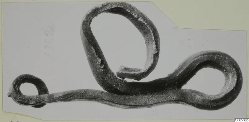 Bronze rod bent into several loops, shown on a mounted grey card, from Vouni