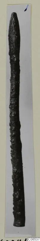 Bronze pin with a pointed top, photographed against a pale background