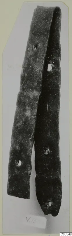 Long narrow bronze strip, bent back on itself, with several rivet holes along its length