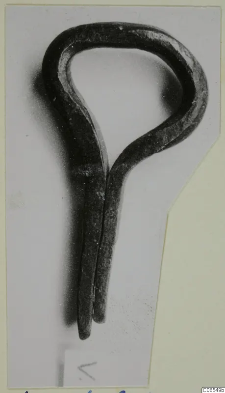 Bronze loop fragment with two tapering prongs, photographed on a mounted card