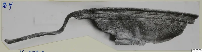Bronze fragment with a curved, ridged rim and a thin strip extending to the left