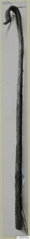 Long metal object with a curled hook at the top, photographed against a plain grey background.