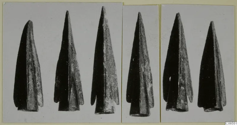 Six dark metal points from Vouni, photographed in three panels on a mounted card