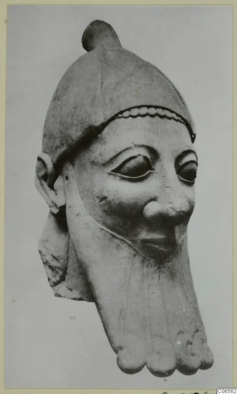Limestone head of a bearded figure wearing a close-fitting cap with a knob on top and a beaded band