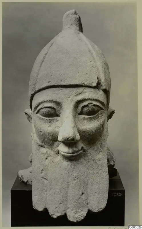 Limestone Proto-Cypriote head of a bearded figure wearing a close-fitting cap with a knob on top