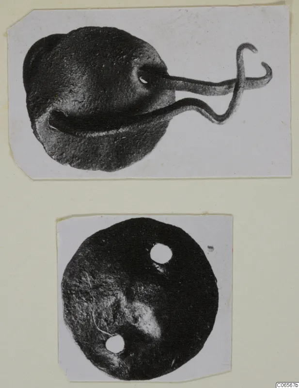 Two bronze fragments: a rounded piece with a bent wire loop, and a flat disc with two holes