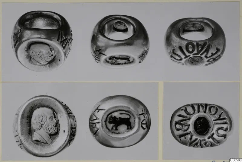 Several views of rings with engraved bezels and lettering around the bands, shown on one mount.
