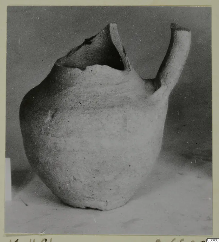 Pale plain pottery jug with a broken open top and a tubular handle, from Kition