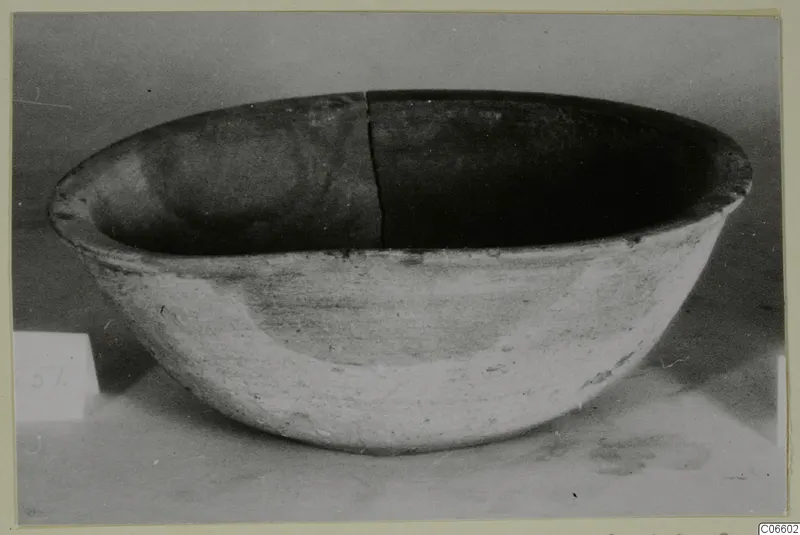 Pottery Plain White VI bowl seen from the side, with a crack running down its rim and interior