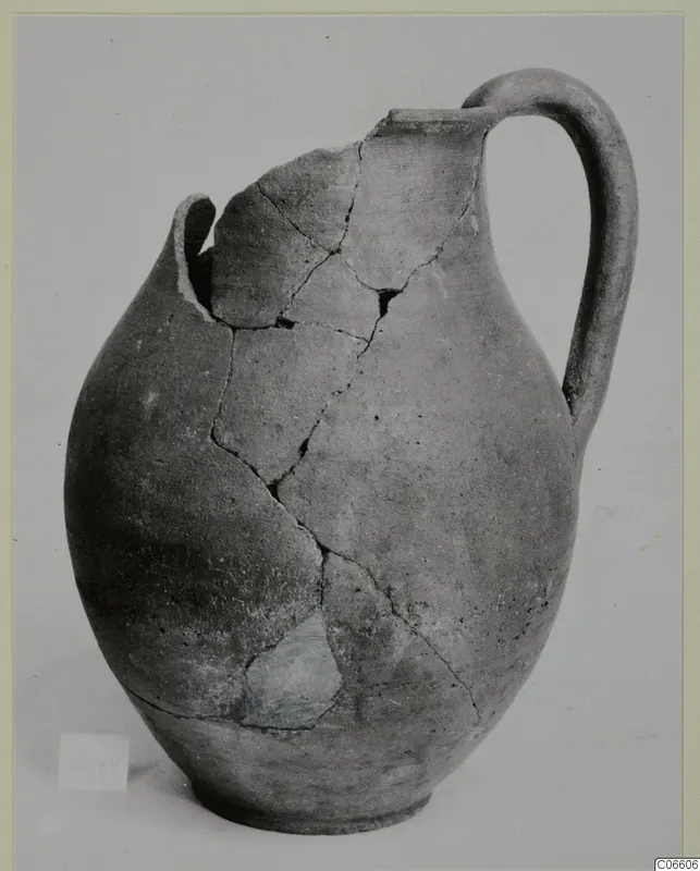 Coarse ware jug from Vouni, reassembled from fragments, with a tall loop handle and rounded body