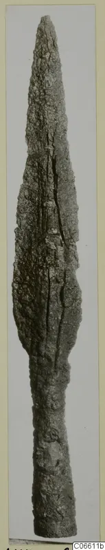 Long corroded iron blade with a pointed tip and narrow shank; find from the Korakas tombs at Vouni