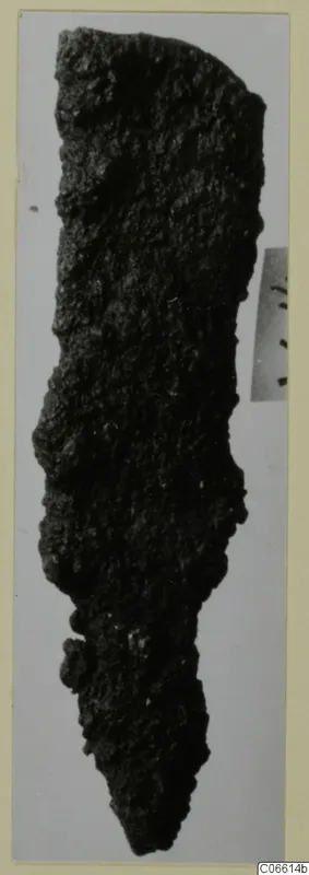 Corroded iron tool fragment from Vouni, long and narrow, tapering to a point at the bottom