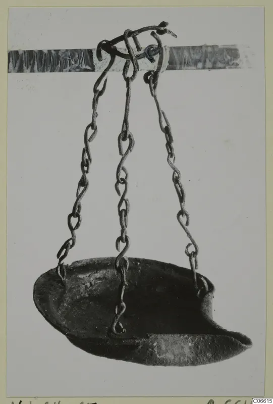 Lamp from Vouni T. 1-16 hanging on three chains from a hook, shown against a pale background.