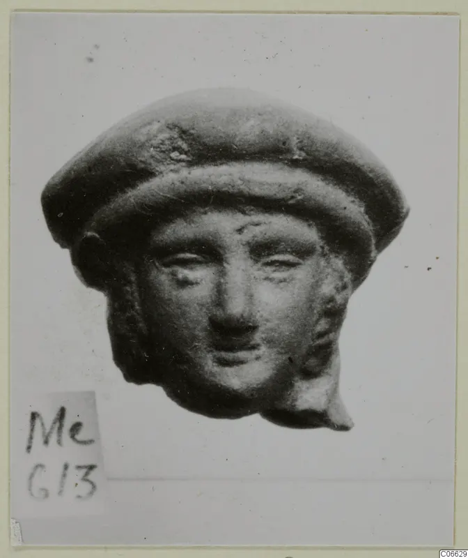 Terracotta head with a rounded cap-like headdress, shown from the front against a pale background