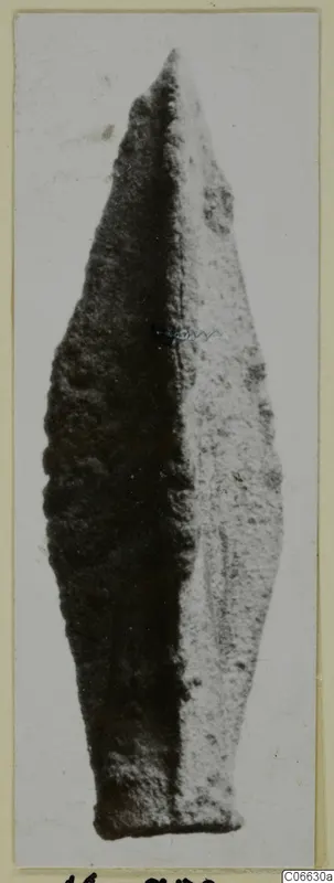Leaf-shaped metal arrowhead from Mersinaki, shown upright on a pale card mount