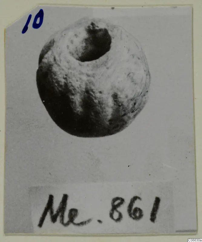 Rounded bead with a large hole at the top, photographed on a card with a handwritten number label