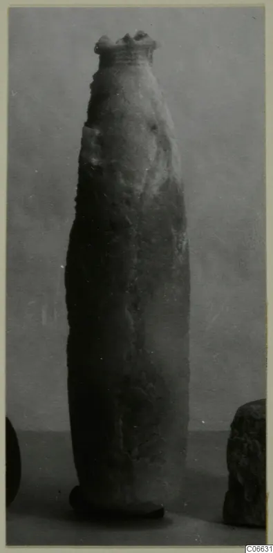 Tall, slender alabaster vessel with a flared rim, from Vouni, photographed against a grey backdrop