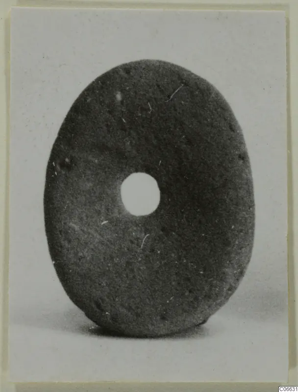 Oval disc with a central hole, a terracotta piece of jewellery.