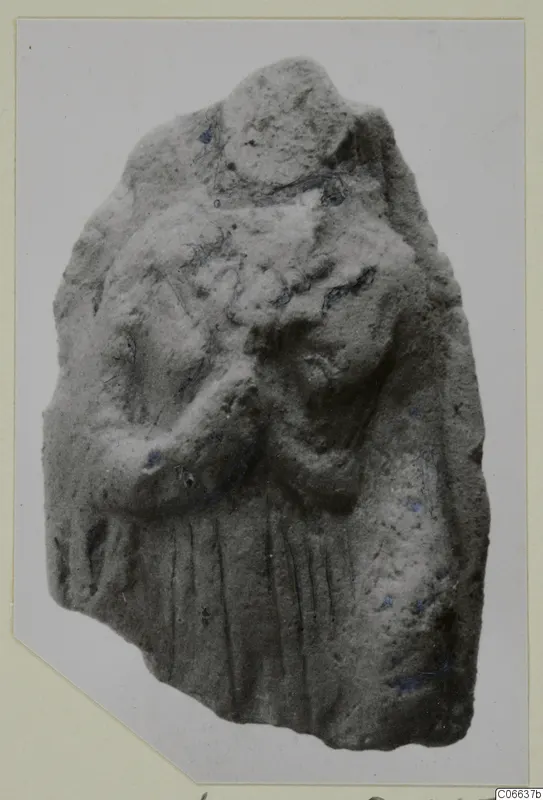Fragmentary terracotta figurine of a standing figure with a bent arm and vertical drapery folds