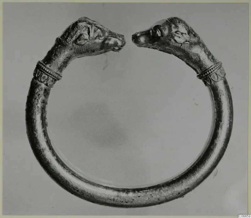 Gold penannular bracelet with animal-head terminals, the two heads facing each other across the gap.