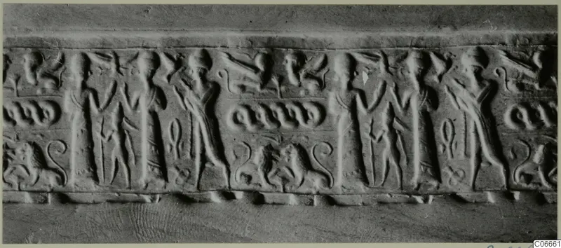 Long carved band with rows of standing figures, paired animals with curled tails and small looped motifs, seen from the front.