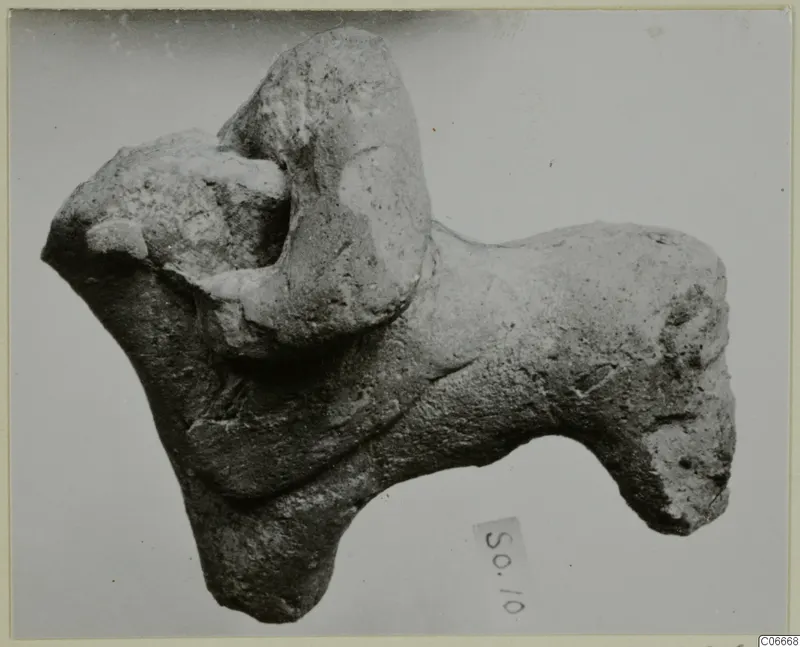 Terracotta animal figurine from Soli, lying horizontally with a number label below it.