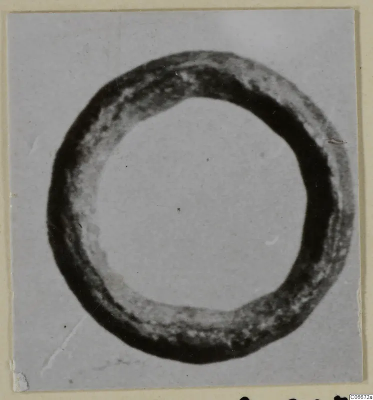 Bronze ring-shaped personal adornment, seen from above against a pale background