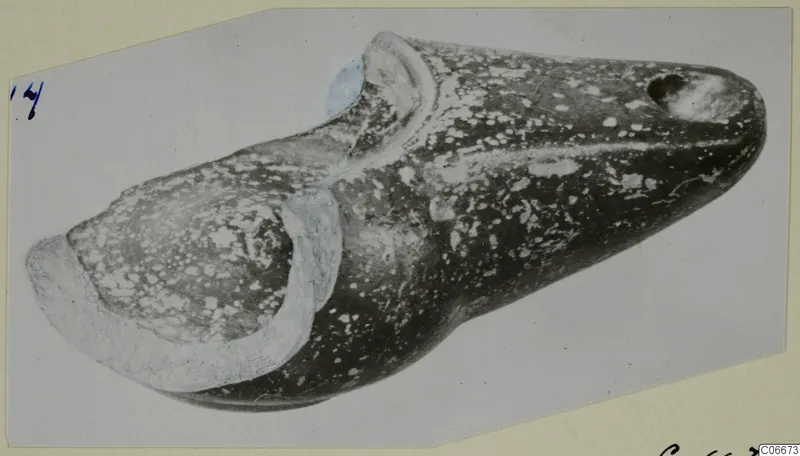 Terracotta lamp with a long tapering spout and a round filling hole, shown diagonally.