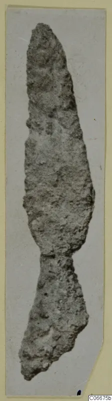 Corroded bronze weapon from Soli with a pointed tip and a broken lower end, shown upright.