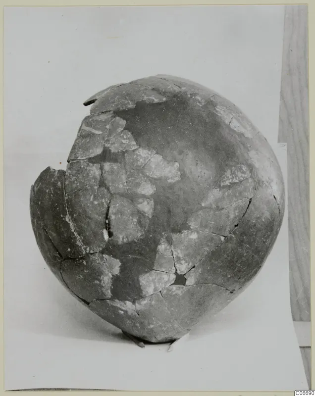 Mended round-bodied pottery vessel, a Red Polished II jug, photographed on a pale background