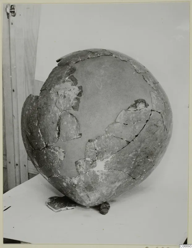 Red Polished II jug, reconstructed from broken fragments, shown on a pale surface