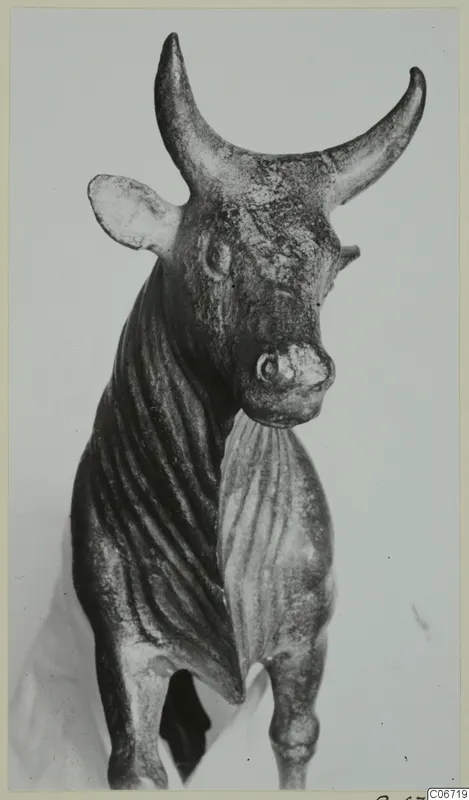 Bronze figurine of a standing bull with upswept horns, pointed ears and a ribbed neck and flank.