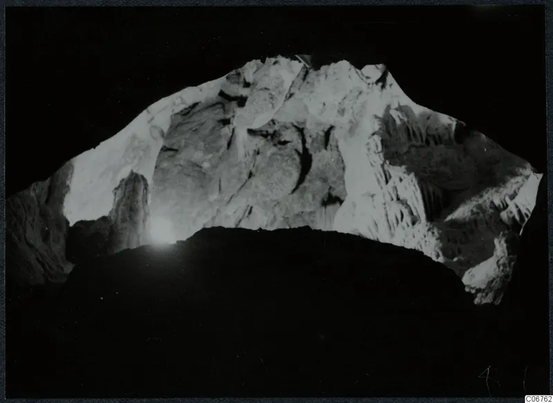 Interior view through a cave opening at Kythrea, with pale rock walls and hanging rock formations