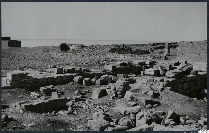 Ruined stone walls of the Temple of Aphrodite, with the sea on the horizon